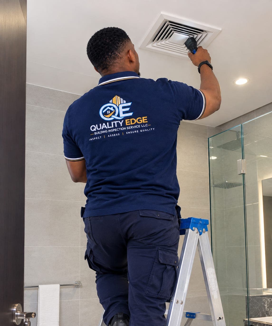An inspector checking a ceiling light fixture with a handheld meter.
